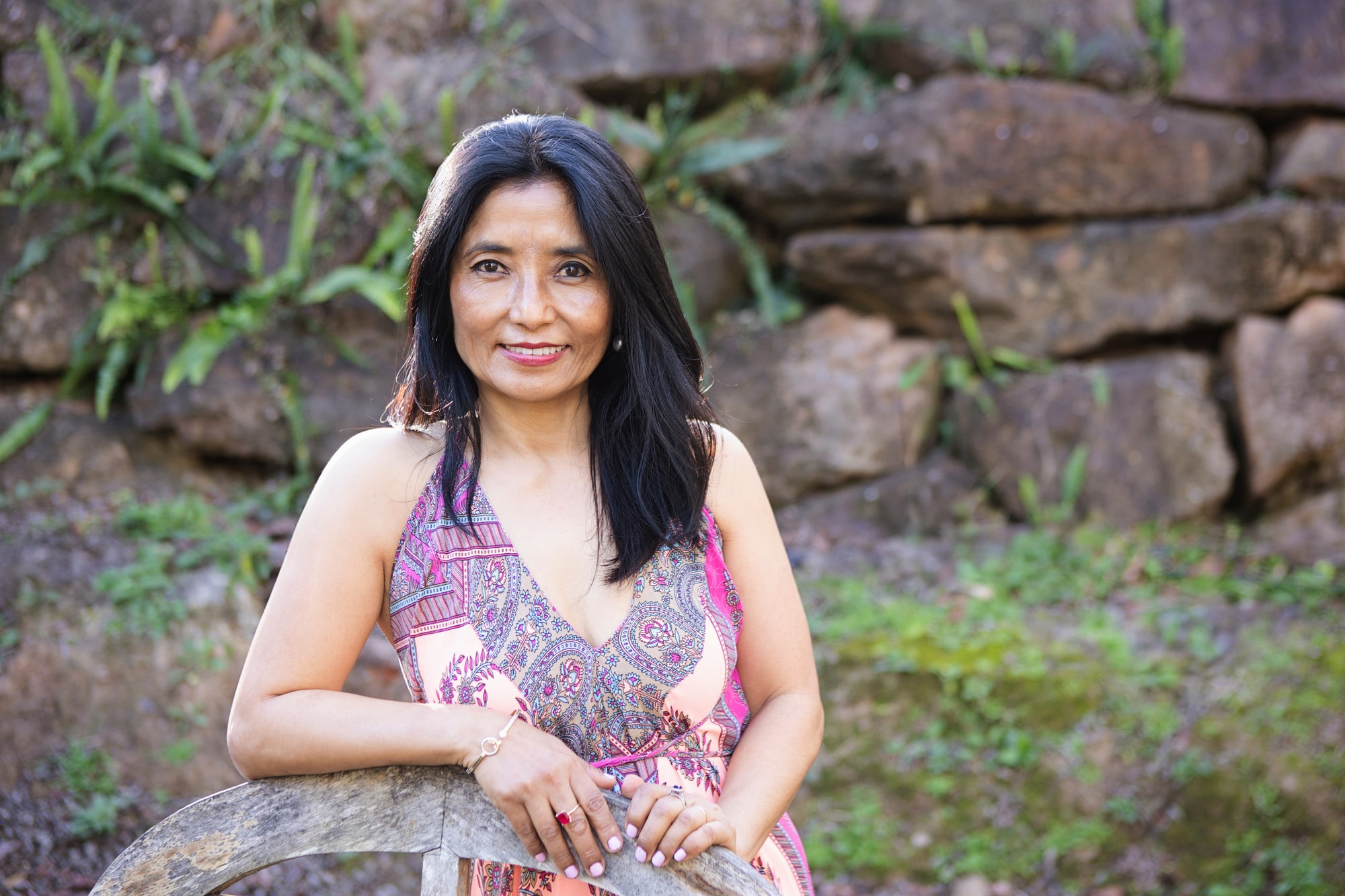 Sonam outdoors in a pink dress with ferns and greenery